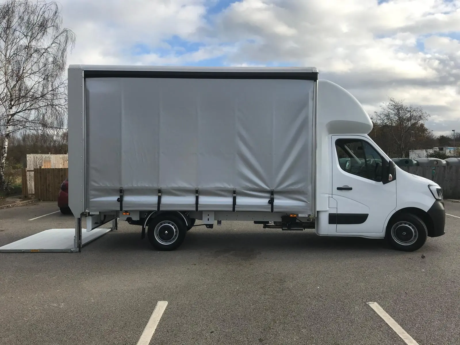 One of the large vans from the side perspective with the loading ramp down